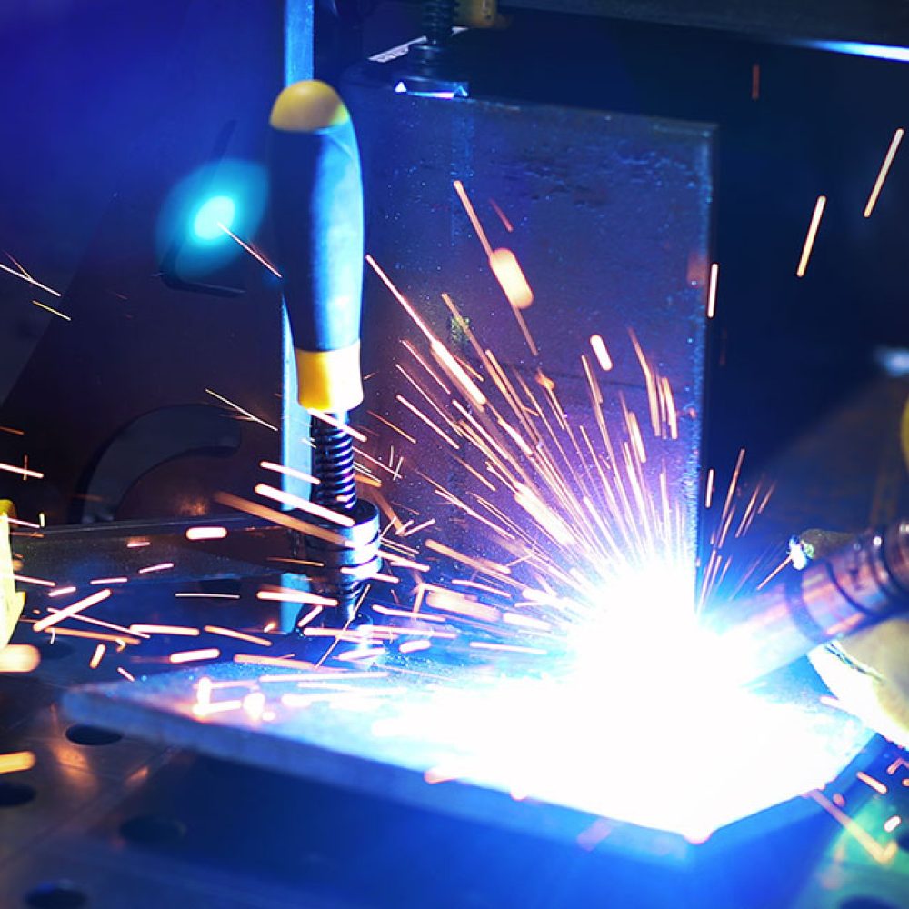 Metal worker welding with torch in metal industry factory